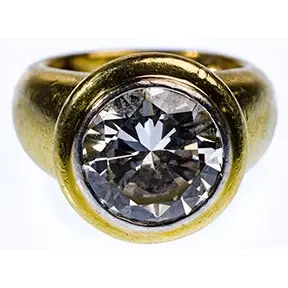 18k gold ring with bezel-set 4.97 carat round brilliant diamond in wide band setting.