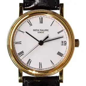 Patek Philippe Calatrava 18k yellow gold wristwatch with white dial, Roman numerals, and black leather strap.